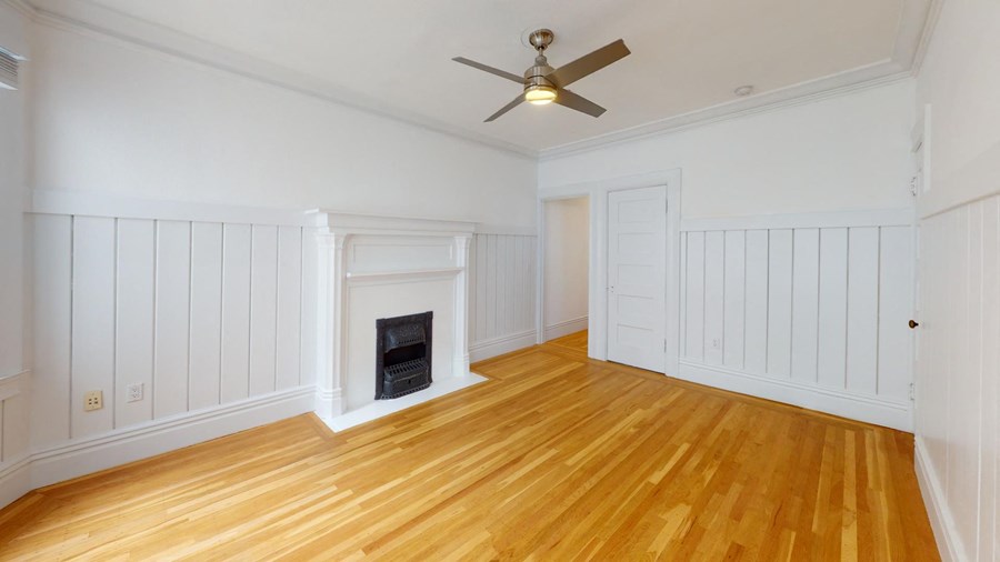 a living room with a fireplace and a ceiling fan